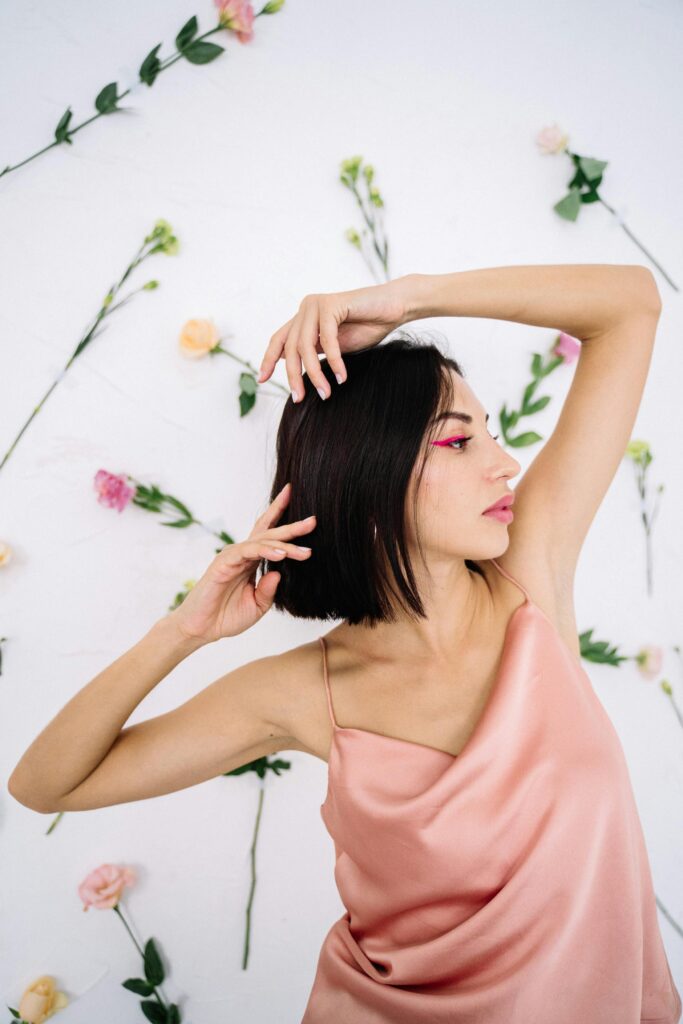 woman in pink dress posing in front of floral background